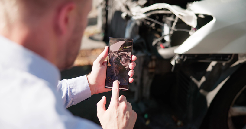 man taking photo of car damage after a car accident: how to dispute a car accident fault