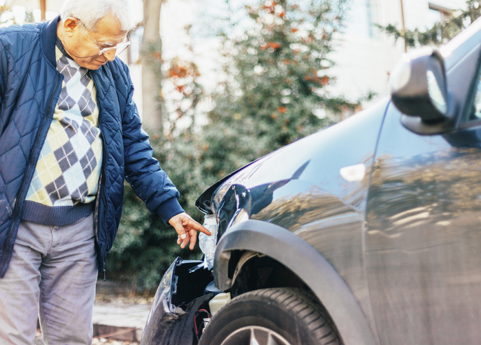 Man standing next to damaged car after an accident - What happens if you lose a car accident lawsuit