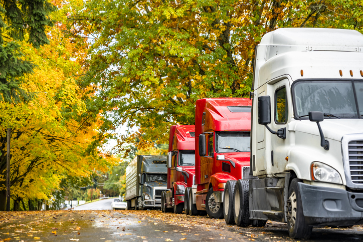 Big rig semi trucks with semi trailers standing in line on street in autumn - when should I consult a lawyer for a truck accident?