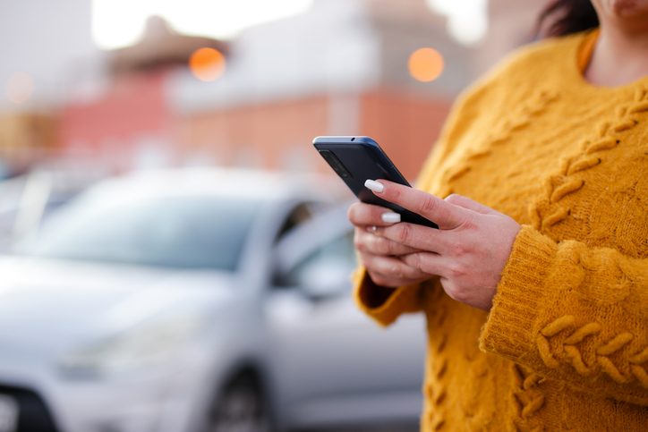 woman making a call near her vehicle - can you reopen a settled car accident case?